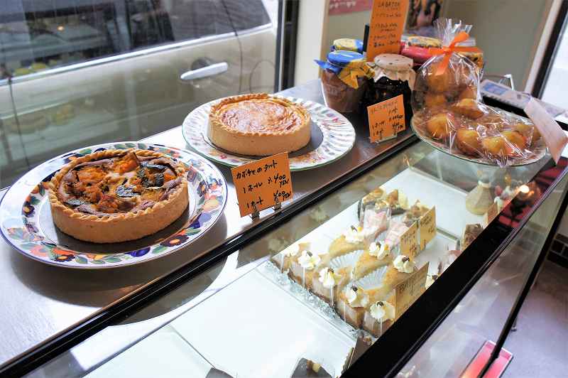 ガラスのショーケースにのせられたホールのケーキや焼き菓子など