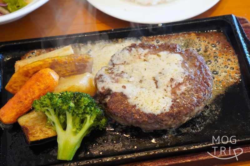 「Hamburg Restaurant Aruhiko（ハンバーグレストランアルヒコ）」のゴルゴンバターハンバーグがテーブルに置かれている