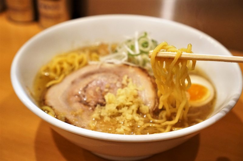 Wスープ味噌ラーメンの麺を箸で持ち上げている様子