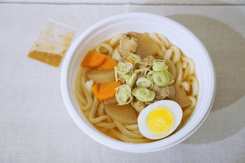 「塩モツ煮込みぶっかけうどん」がテーブルに置かれている