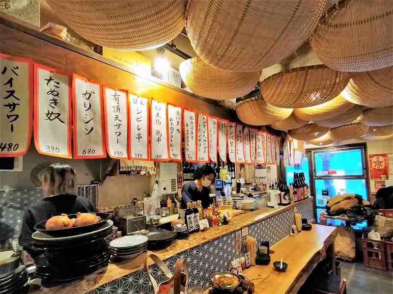 北海道木のカウンターがある「大衆酒場 有頂天」の店内