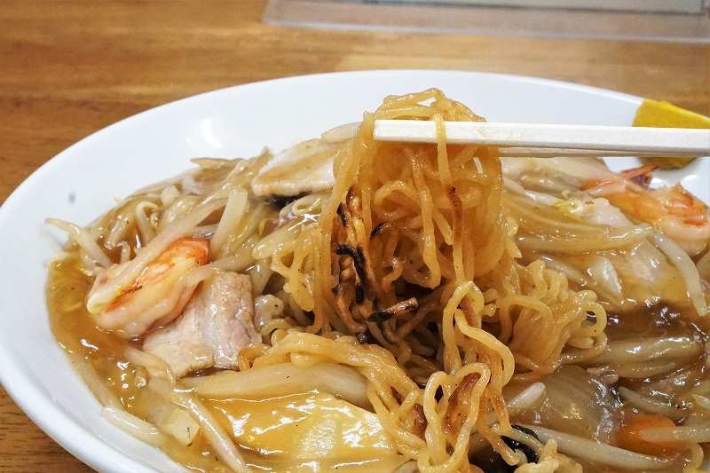 あんかけ焼きそばの中華麺を箸で持ち上げている様子