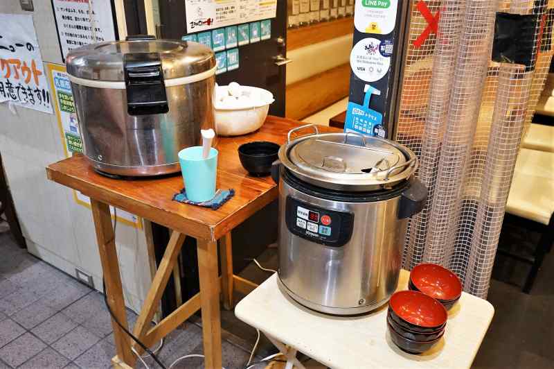 炊飯器、大きなお鍋などがテーブルに置かれている