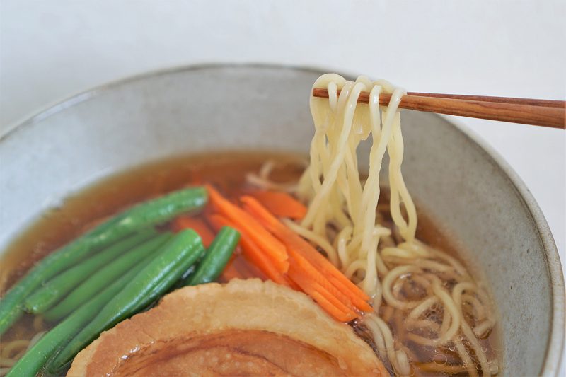 ラーメンの麺を箸で持ちあげている様子