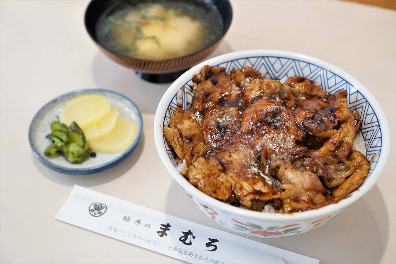 豚丼のまむろの豚丼や味噌汁がテーブルに置かれている