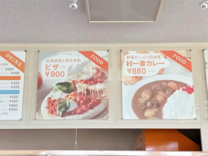 ピザとカレーのメニュー表が壁に貼られている