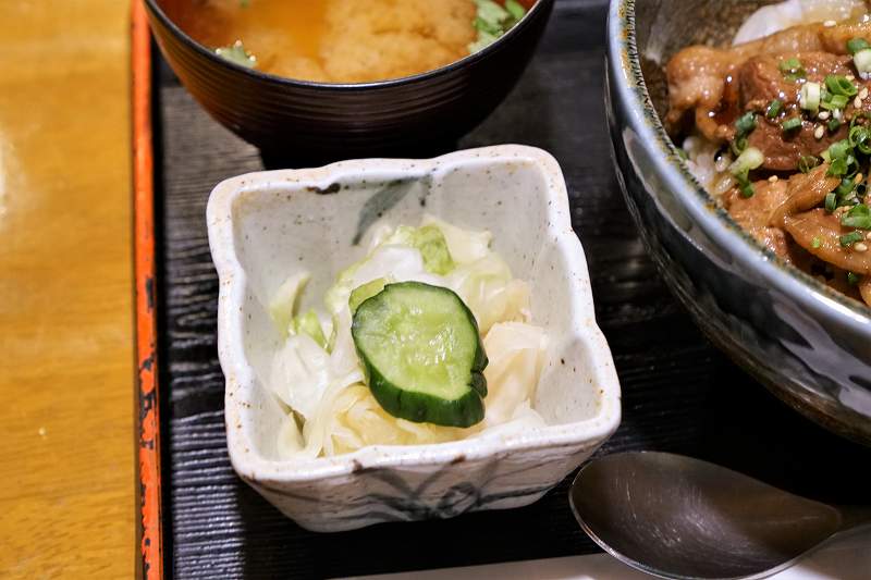 お新香や味噌汁、丼がテーブルに置かれている