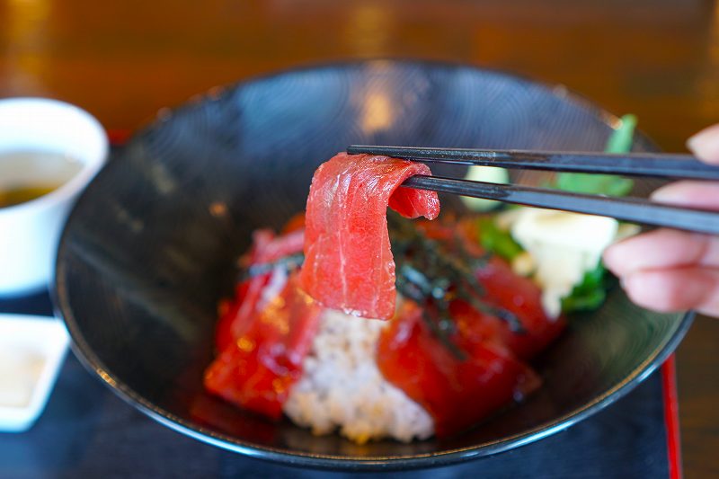 マグロ丼のマグロを箸で持ち上げている様子