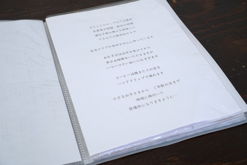 「おむすびcafe粒」のこだわりの説明が書かれた冊子がテーブルに置かれている