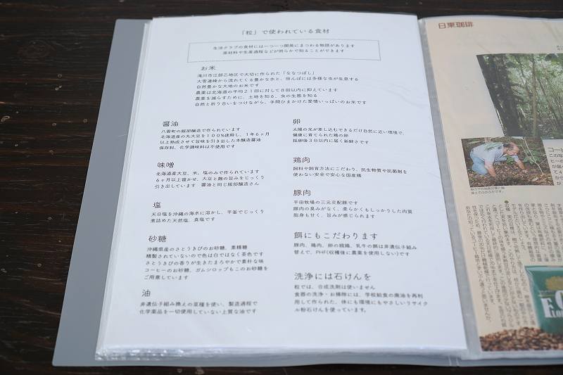 「おむすびcafe粒」のこだわりの説明が書かれた冊子がテーブルに置かれている