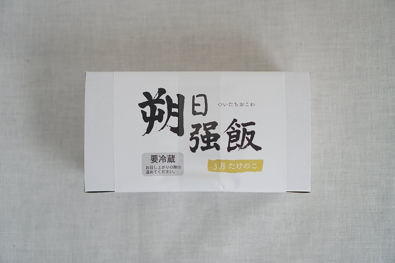 「六花亭 朔日おこわ」の3月分 たけのこおこわの箱がテーブルに置かれている