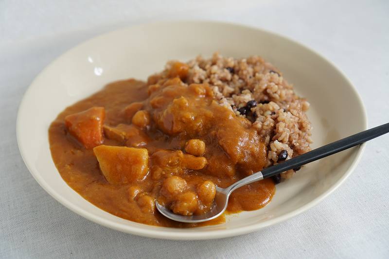 お皿に盛られた「野菜ごろごろひよこ豆のチキンカレー（小辛）」がテーブルに置かれている