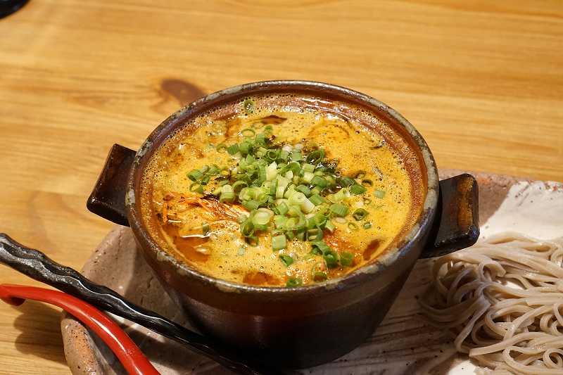 「えびつけ麺カレーそば」のつけ汁がテーブルに置かれている