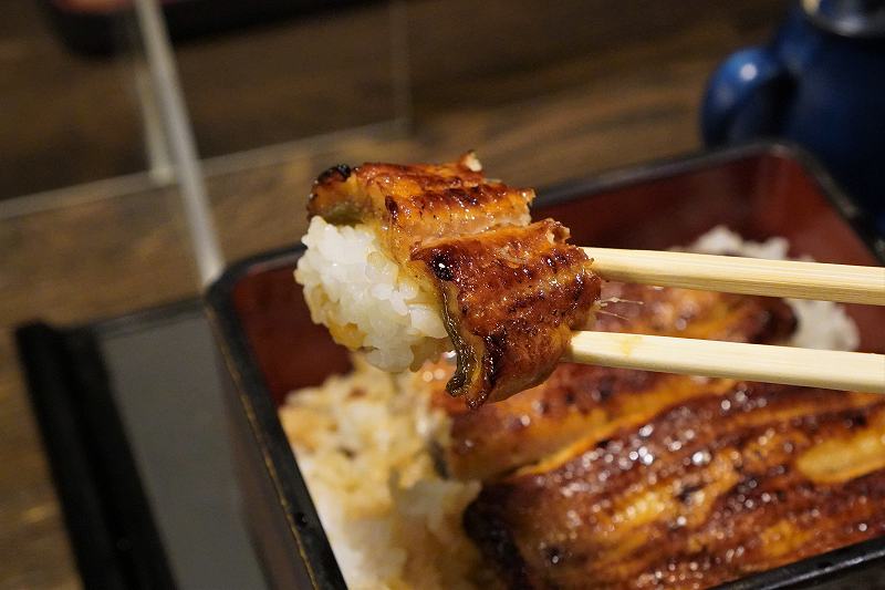 うなぎのかど屋　うな重を箸で持ち上げている様子