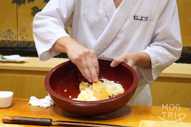 おしどりの名物・無敵のうに丼のシャリを大将が混ぜている様子