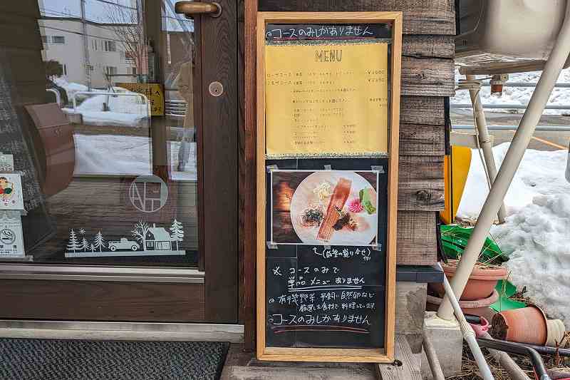 札幌にある「自家製生パスタと旬菜イタリアンagio（アジオ）」のメニューが入口の横に立てられている