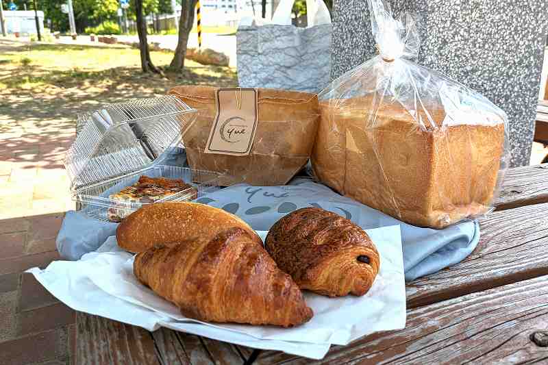 札幌「boulangerie yue.（ブーランジェリーユエ）」のクロワッサンや角食が木のベンチに置かれている