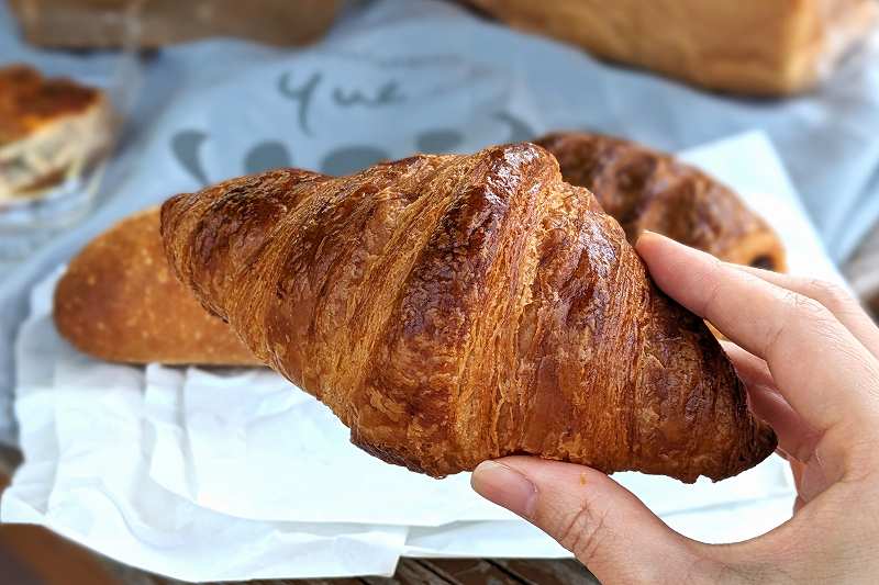 札幌「boulangerie yue.（ブーランジェリーユエ）」のクロワッサンを手に持っている様子