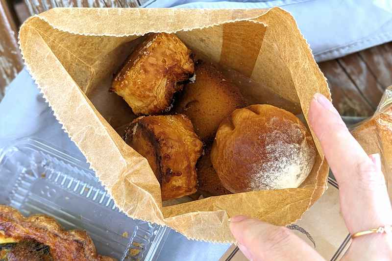 札幌「boulangerie yue.（ブーランジェリーユエ）」の袋入り焼き菓子をあけている様子